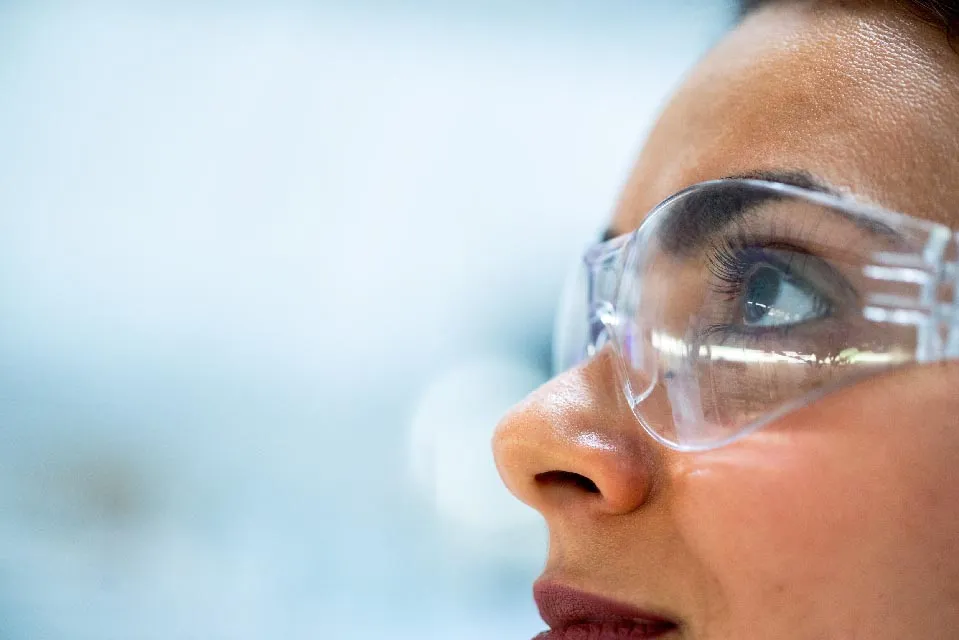 A female lab technician wearing PPE safety glasses